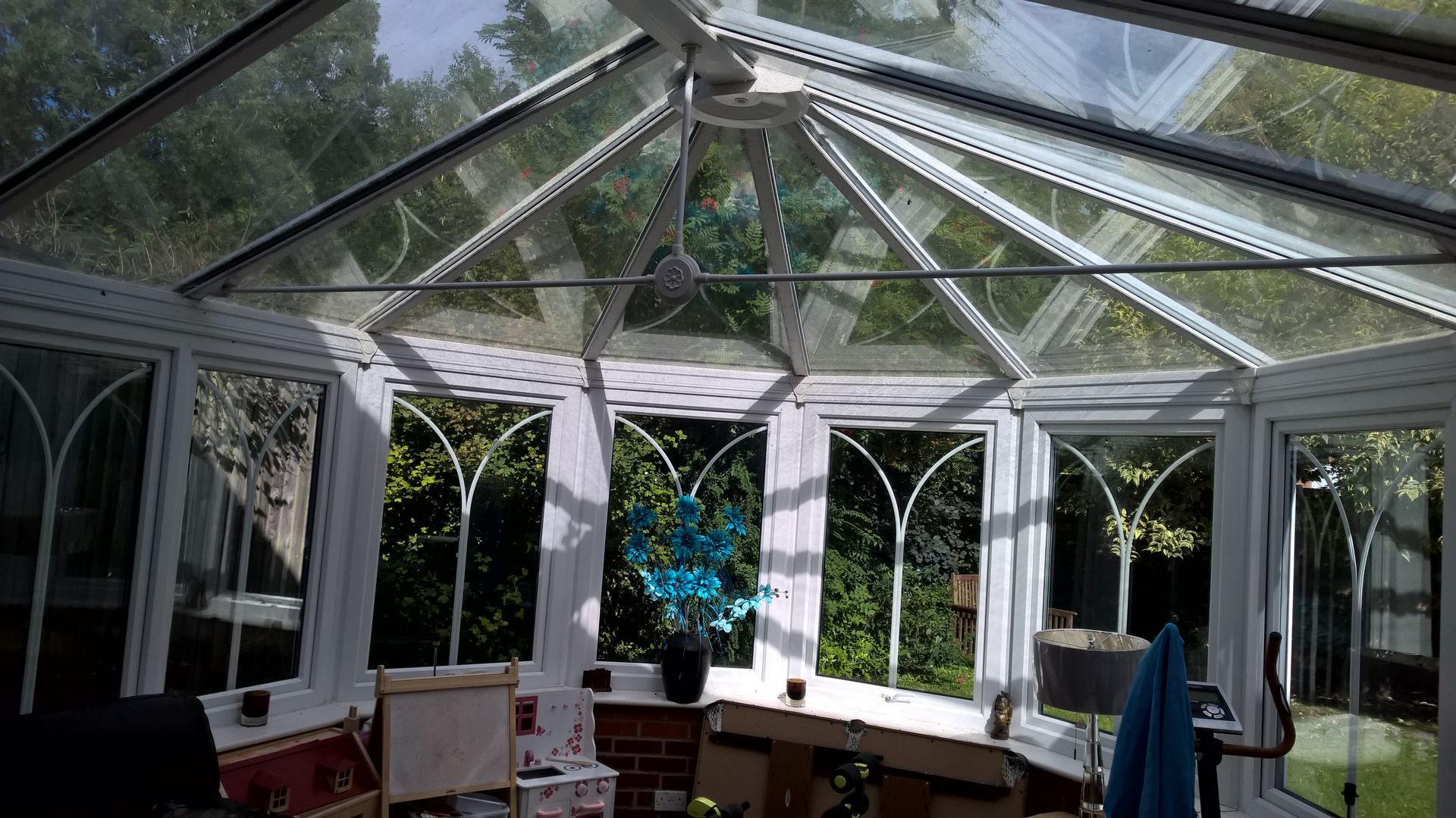 A conservatory with a glass roof and lots of windows.