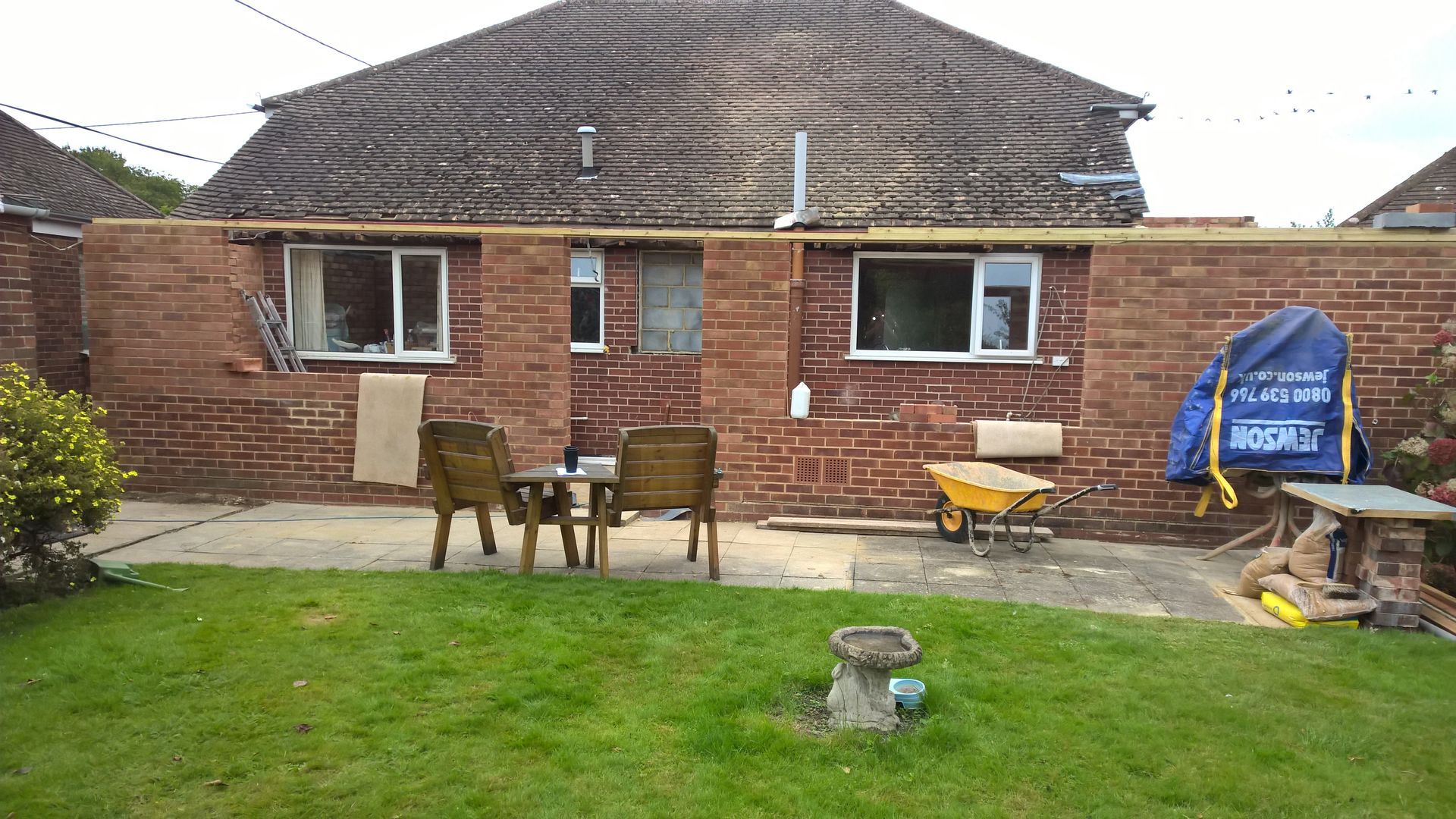 A brick house with a patio area in front of it.