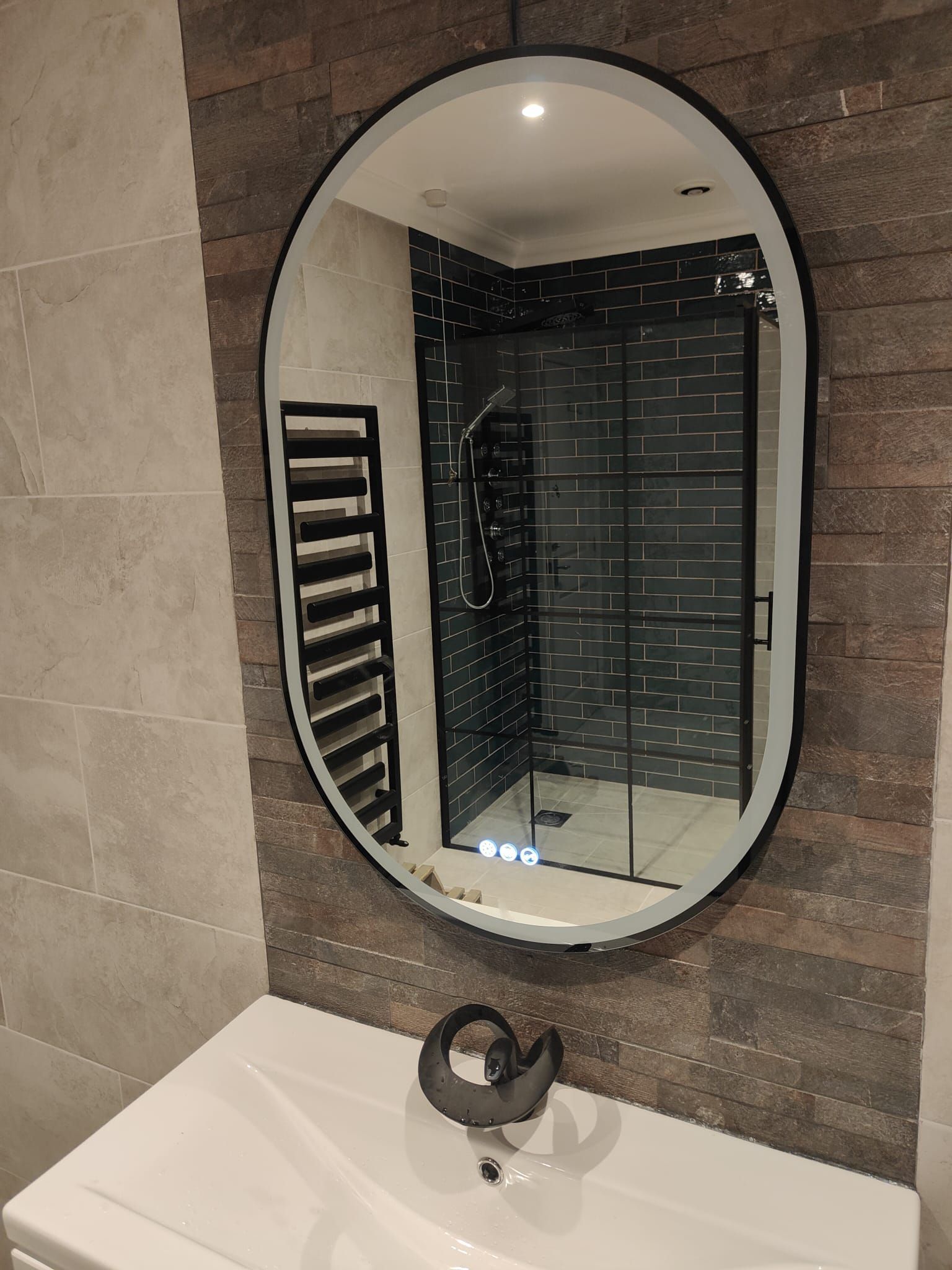 A bathroom with a round mirror on the wall above a sink.