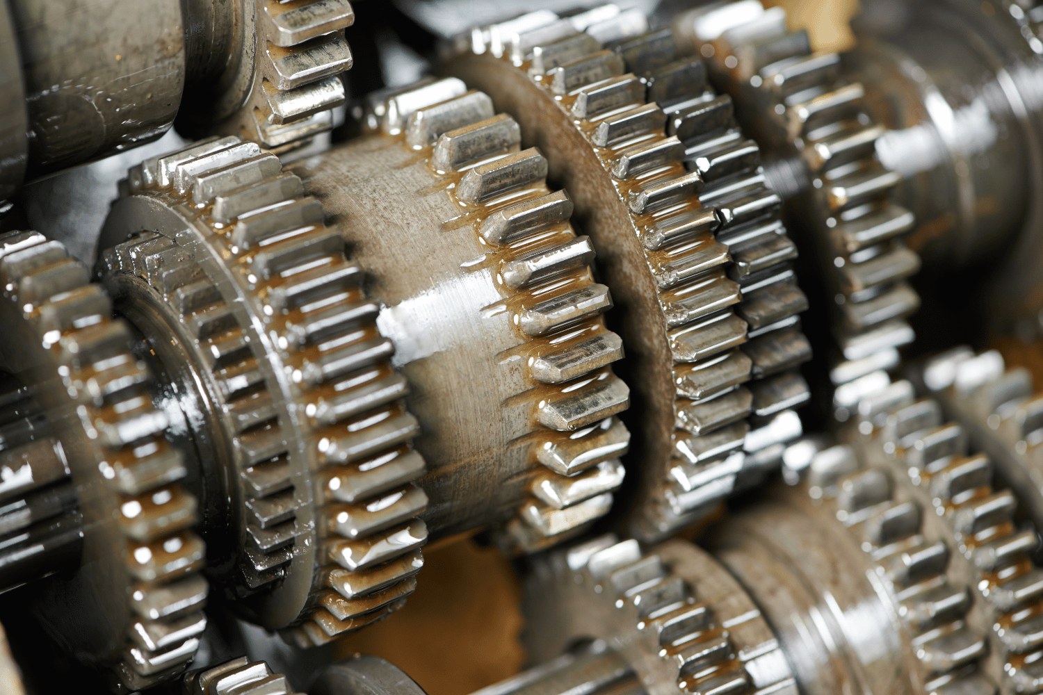Close-up of interlocking metal gears in a mechanical assembly, showing a shiny industrial gearbox.