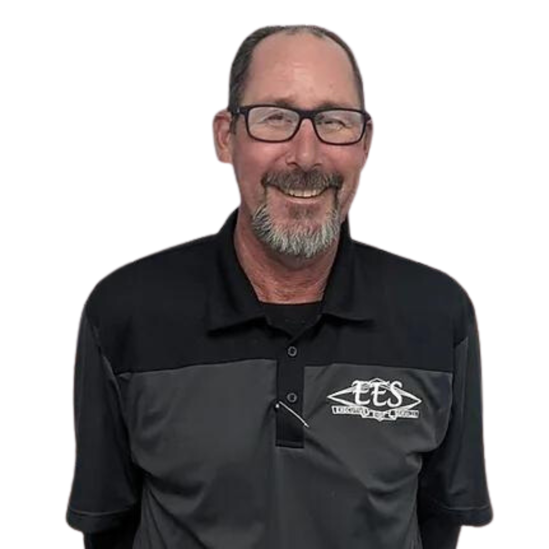 A man with glasses and a beard is wearing a black shirt and smiling.