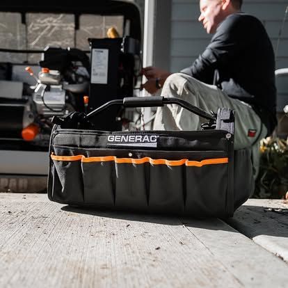Portable generator beside a white utility building on a grassy lawn near modern offices