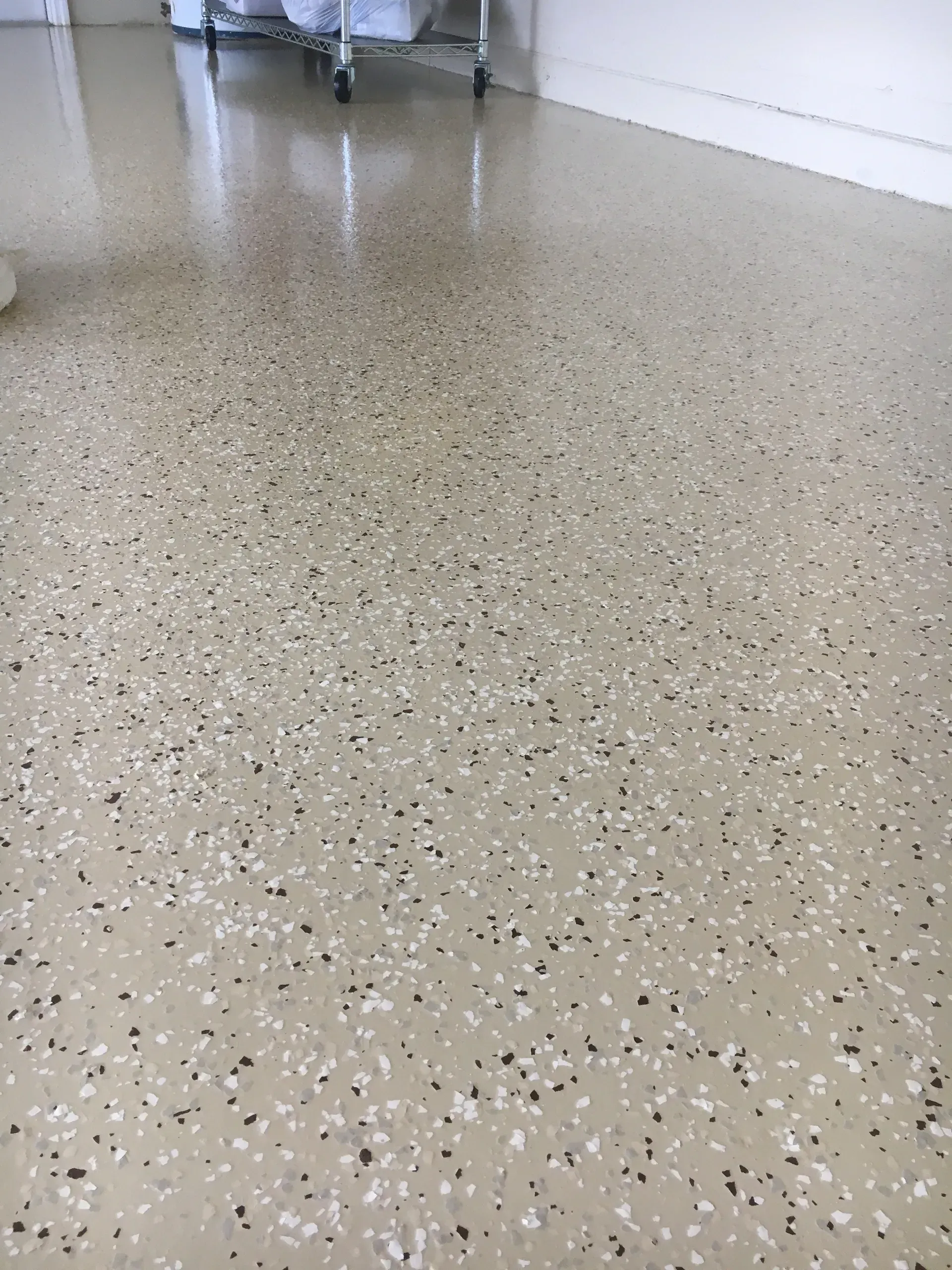 Tan speckled floor with white and black chips, possibly epoxy, in a medical setting.