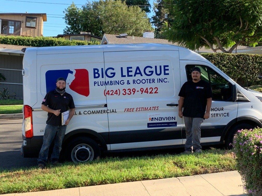Big League Plumbing & Rooter Inc. service van parked on a residential street, with two employees standing beside it