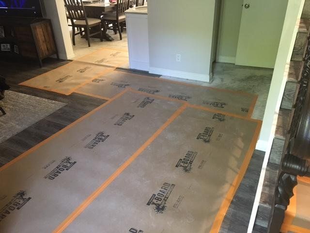 Floor covered with brown protective paper taped down in a partially renovated room