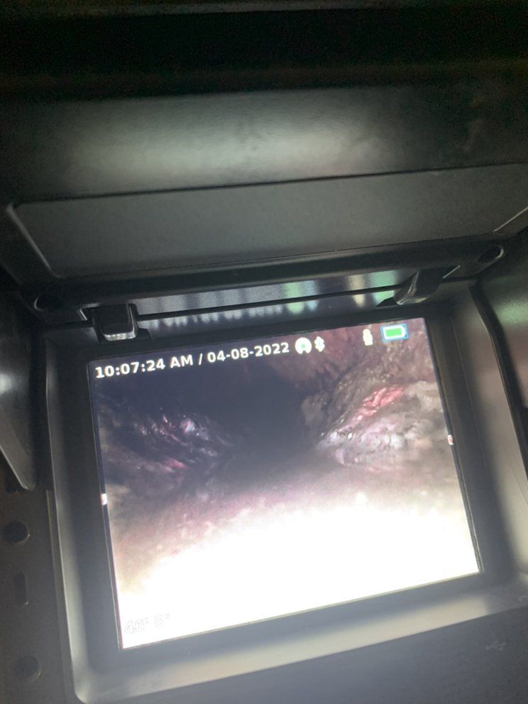 Car dashboard display showing a blurry night-time rearview camera feed with date and time overlay