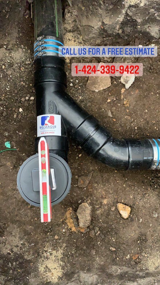 Black drainage pipe with cleanout cap in dirt, overlaid with “Call us for a free estimate” and a phone number.