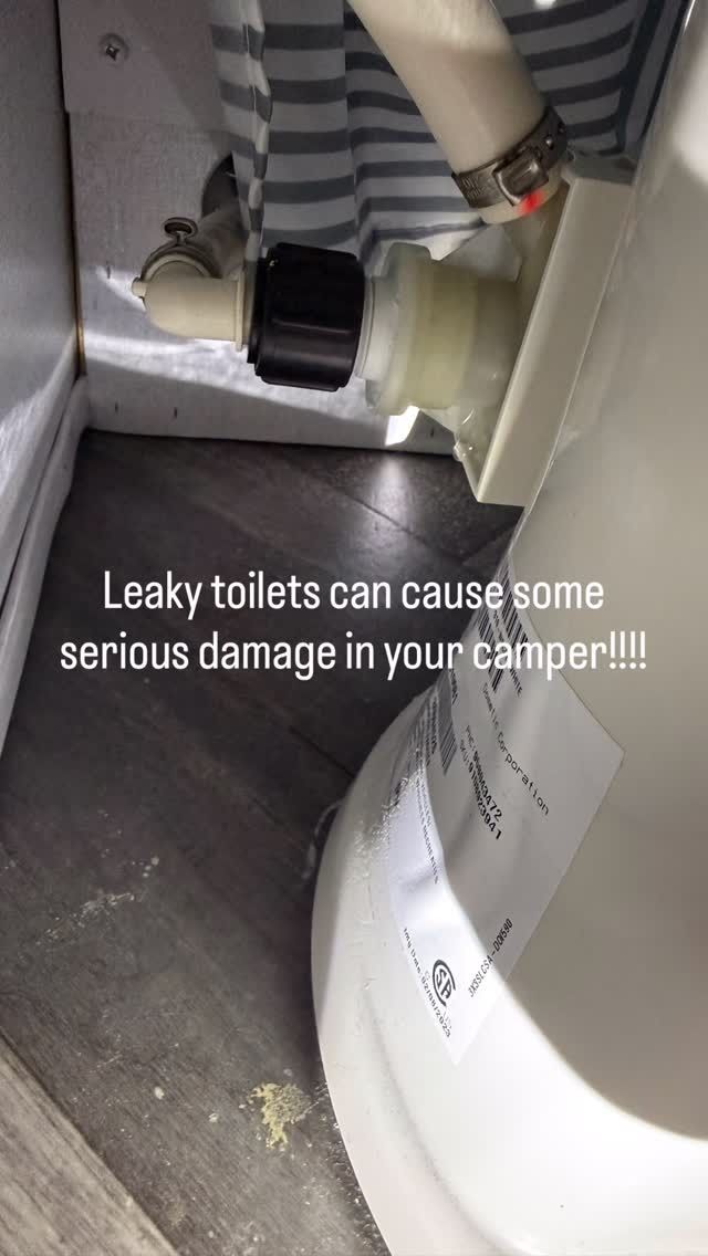 Leaking toilet pipe dripping onto bathroom floor beside a white toilet and gray wall.