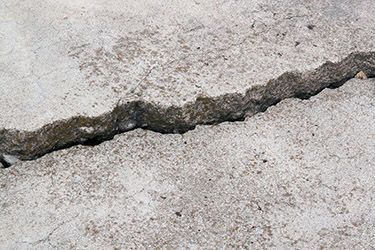 Cracked concrete pavement with a long jagged fracture line