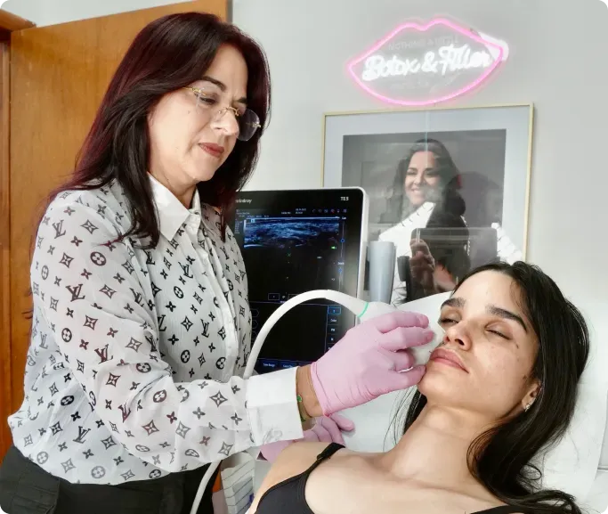 Woman using medical equipment on patient's face in a clinic. Pink-gloved hands, screen, and neon sign