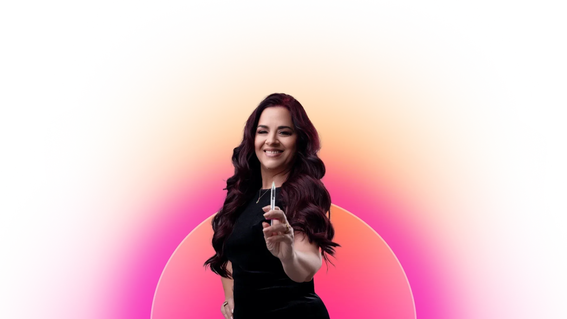 Woman in black holding a small object with a colorful gradient background.
