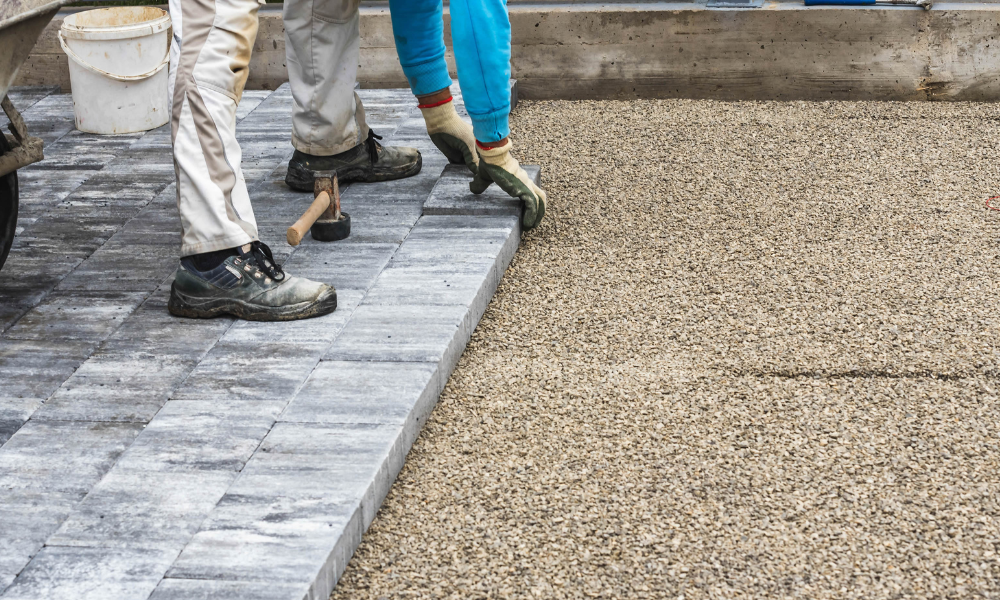 A group of people are working on a sidewalk.