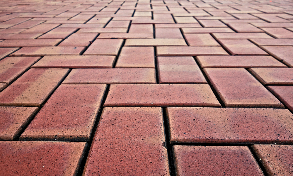 A close up of a brick walkway with a herringbone pattern