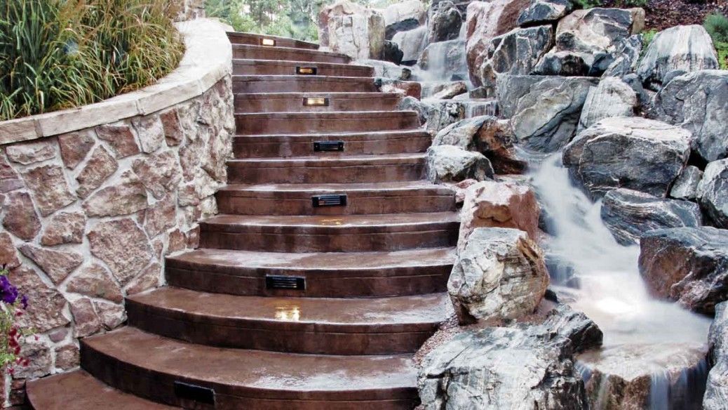 A set of stairs leading up to a waterfall surrounded by rocks.