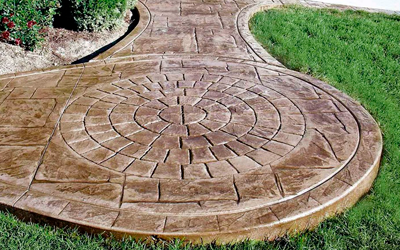 A concrete walkway with a circular design on it