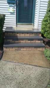 A set of brick steps leading up to the front door of a house.