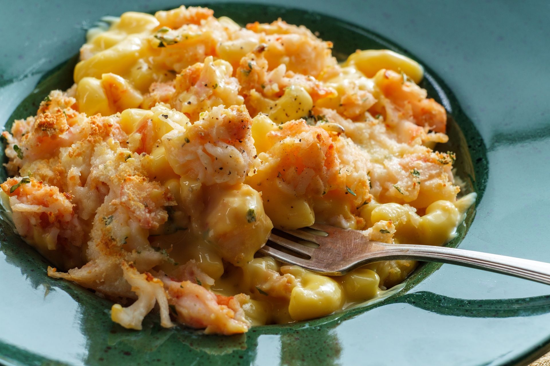 A plate of macaroni and cheese with a fork in it.
