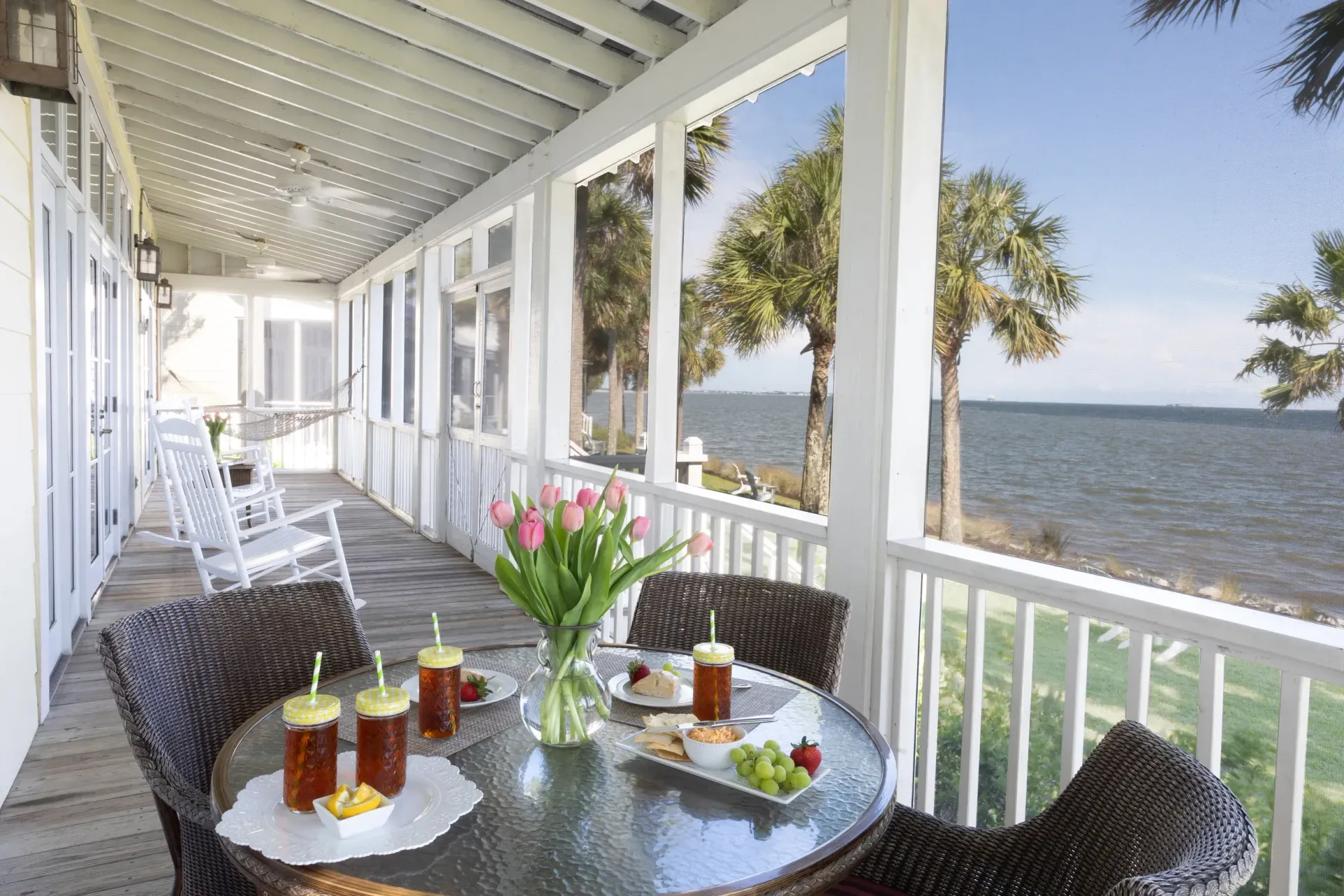 A porch with a table and chairs overlooking the ocean