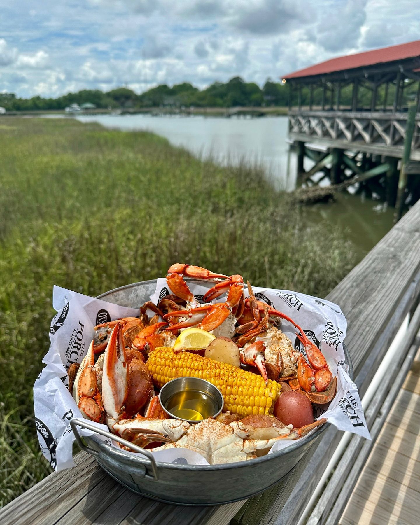 A plate of shrimp with a slice of lemon on a wooden table.