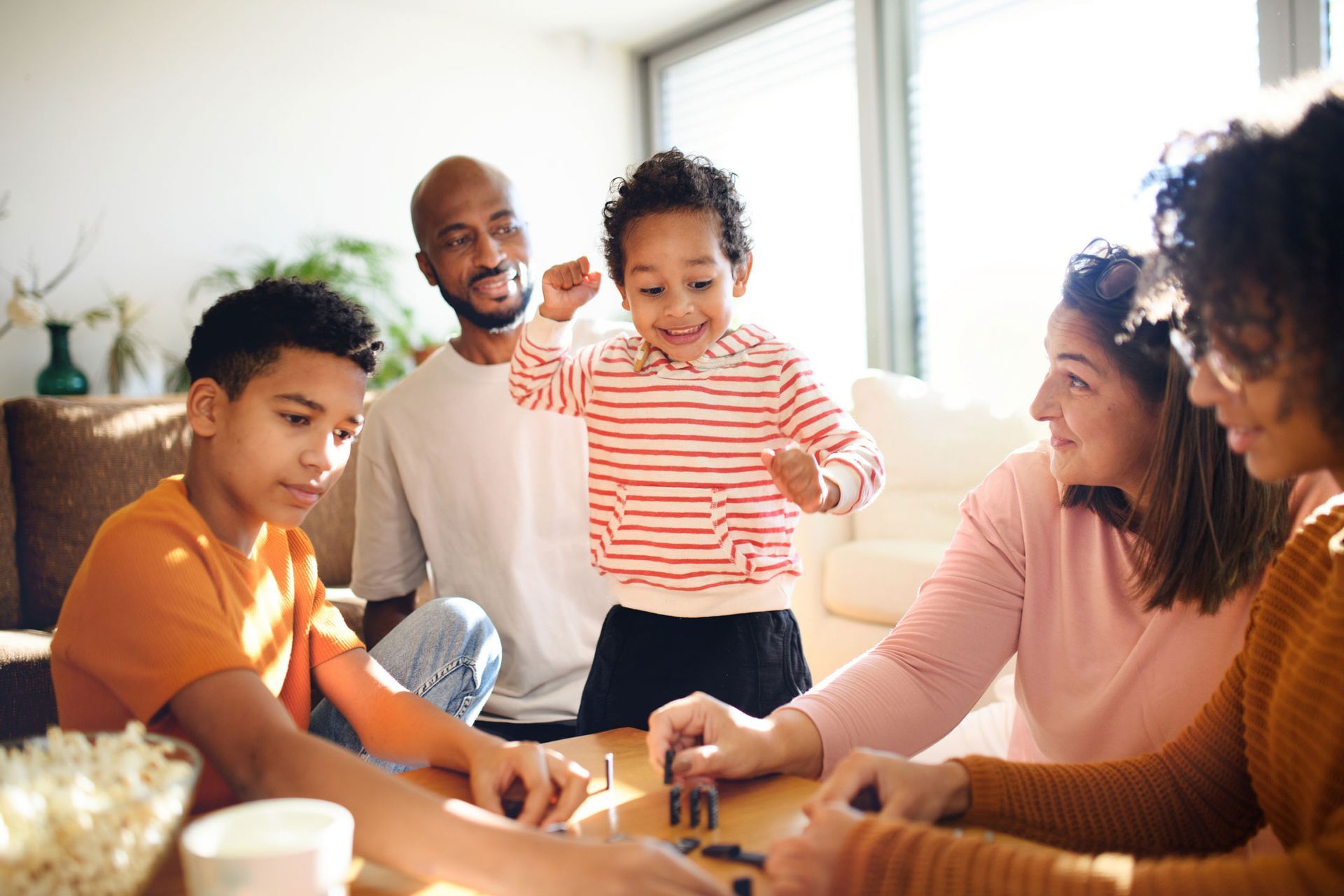 A family is sitting around a table playing a game.