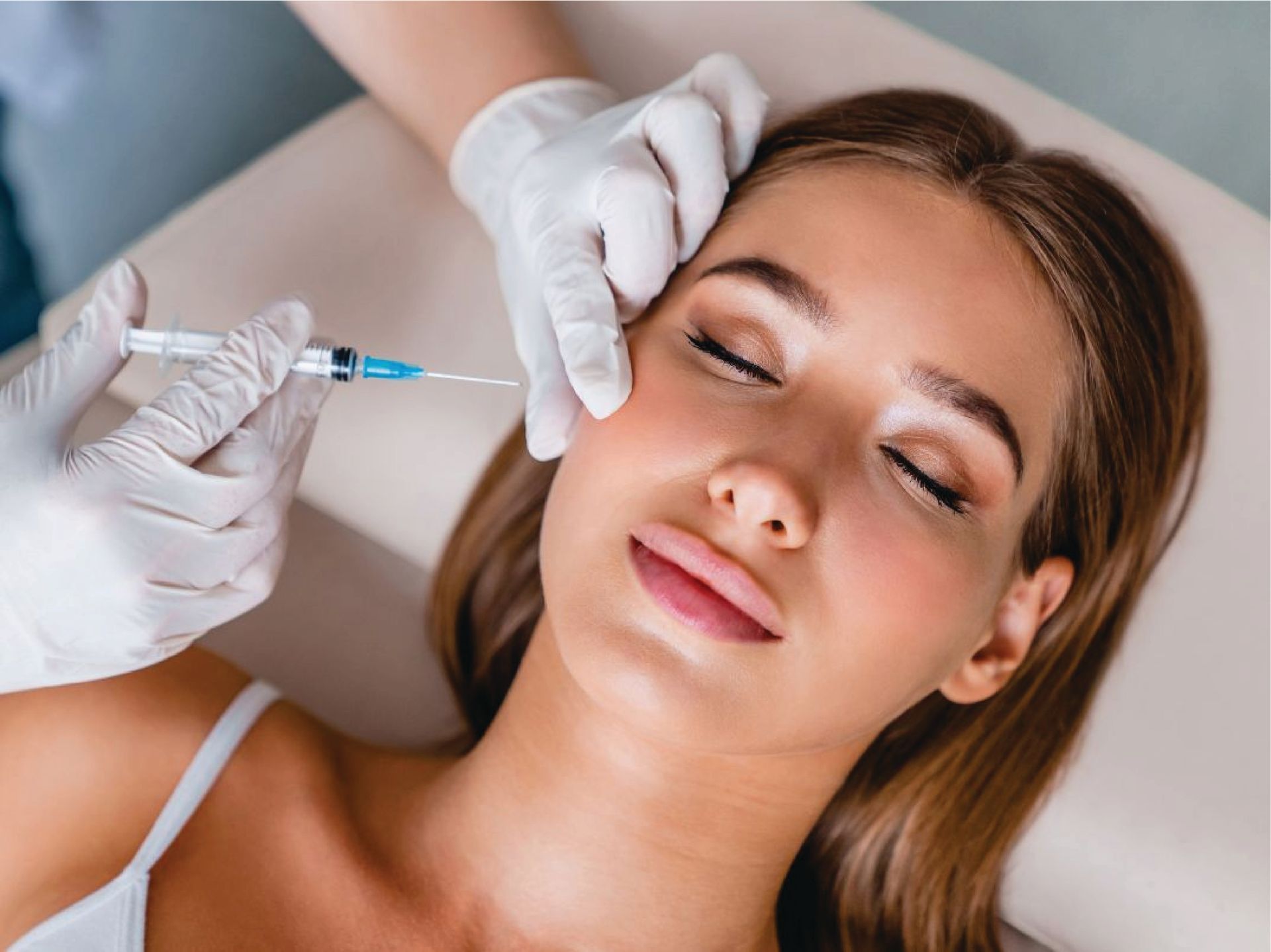 Cosmetologist injects a syringe into a woman’s face during a beauty treatment