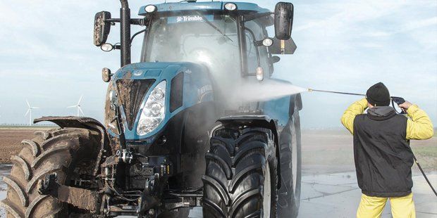 Cleaning A Huge Tractor Full Of Dirt — Albany, OR — Sure-Clean NW A man cleaning with pressure cleaning equipment in Salem, OR