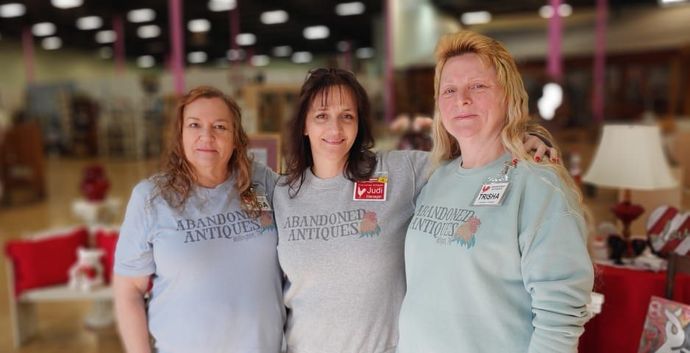 Three women are posing for a picture in a store.