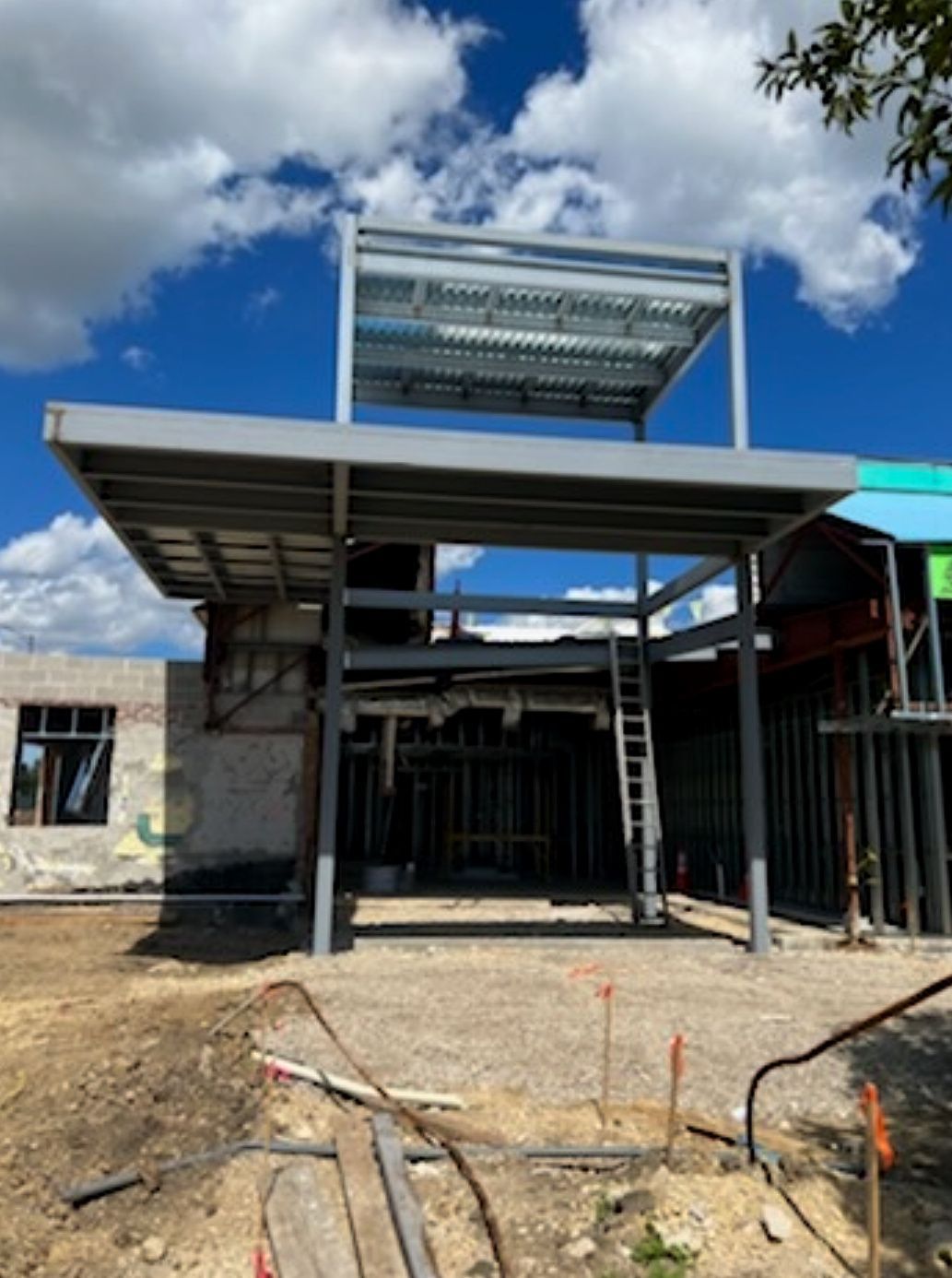 Partly built house with steel roof framing and blue sky above