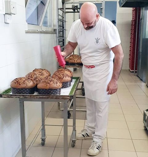 pasticcere guarnisce panettoni
