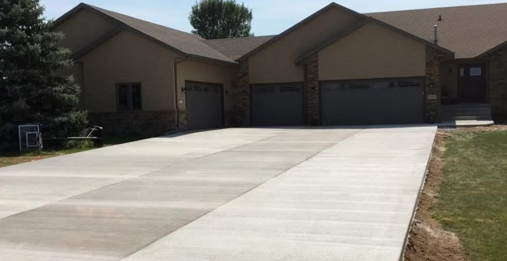 Suburban house with a wide concrete driveway and two garage doors