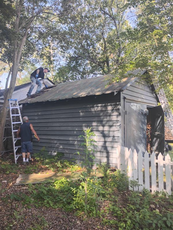 The exterior of a mobile home featuring white horizontal siding and a brick-patterned foundation under a clear blue sky.
