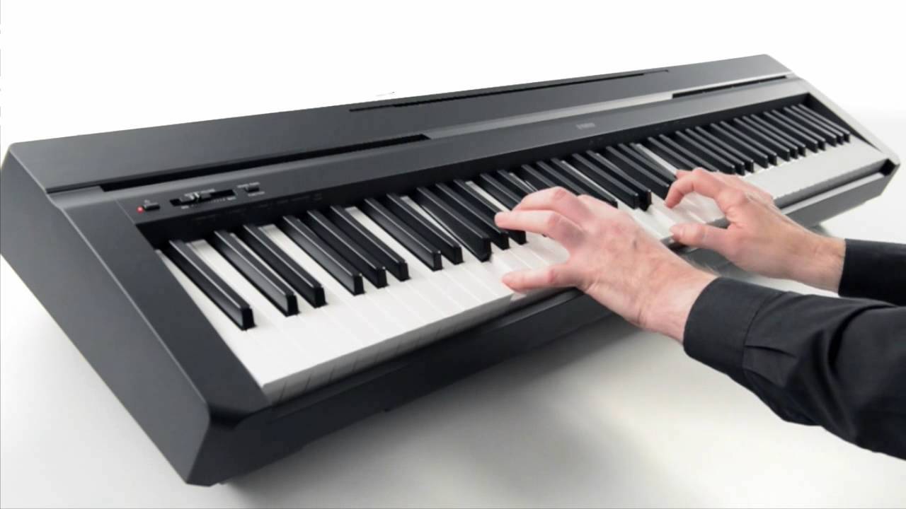 A person is playing a piano with their hands on the keys.