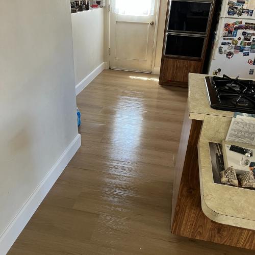 A kitchen with hardwood floors and a stove top oven