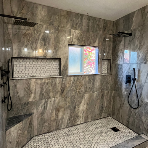A bathroom with a walk in shower and a window.