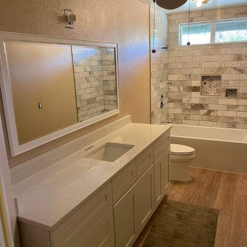 A bathroom with a sink , toilet , tub and mirror