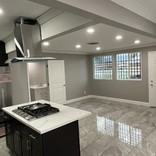 A kitchen with a stove top oven and a sink