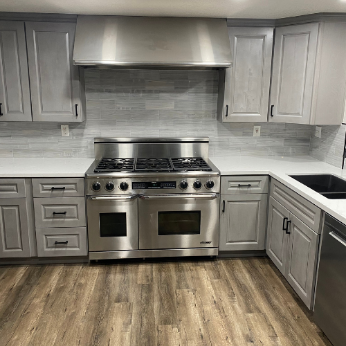 A kitchen with stainless steel appliances and gray cabinets