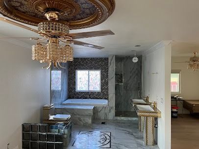 Luxurious bathroom with ornate ceiling fan, tub, and marble accents.