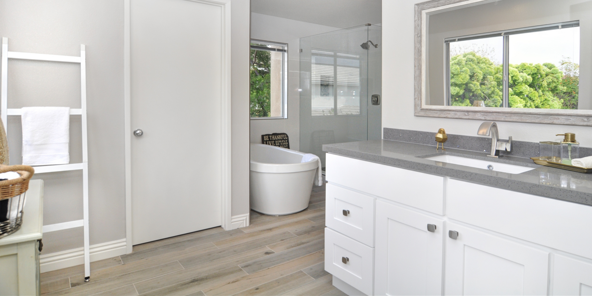 A bathroom with a tub , sink and mirror.