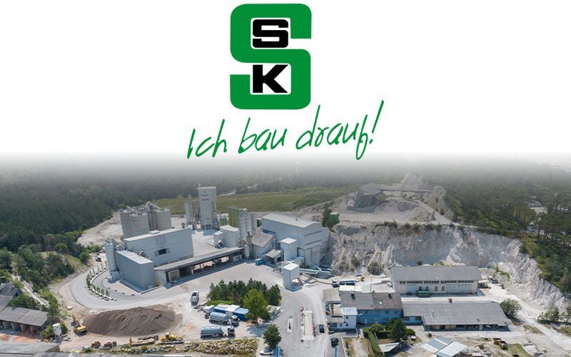 Logo von der Firma SSK Salzburger Sand und Kieswerke mit einem Kieswerk im Hintergrund