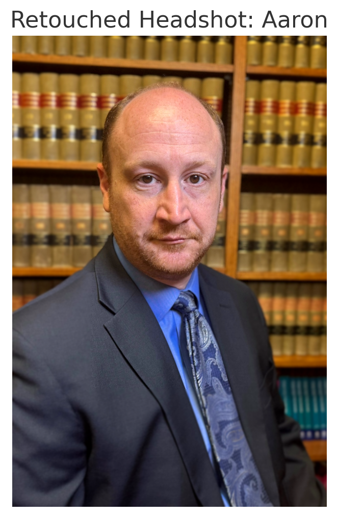 A man in a suit and tie is standing in front of a bookshelf
