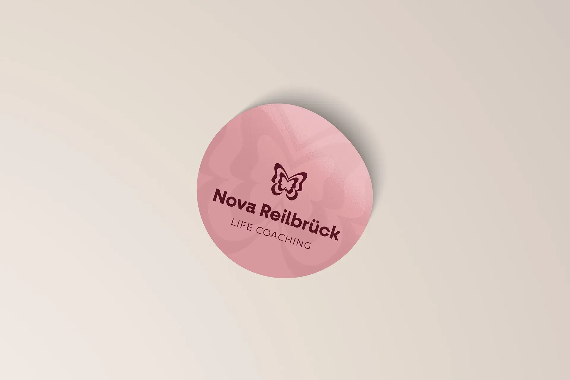 Auf einer weißen Fläche befindet sich ein rosa Aufkleber mit der Aufschrift „Nova Reilbrück“.