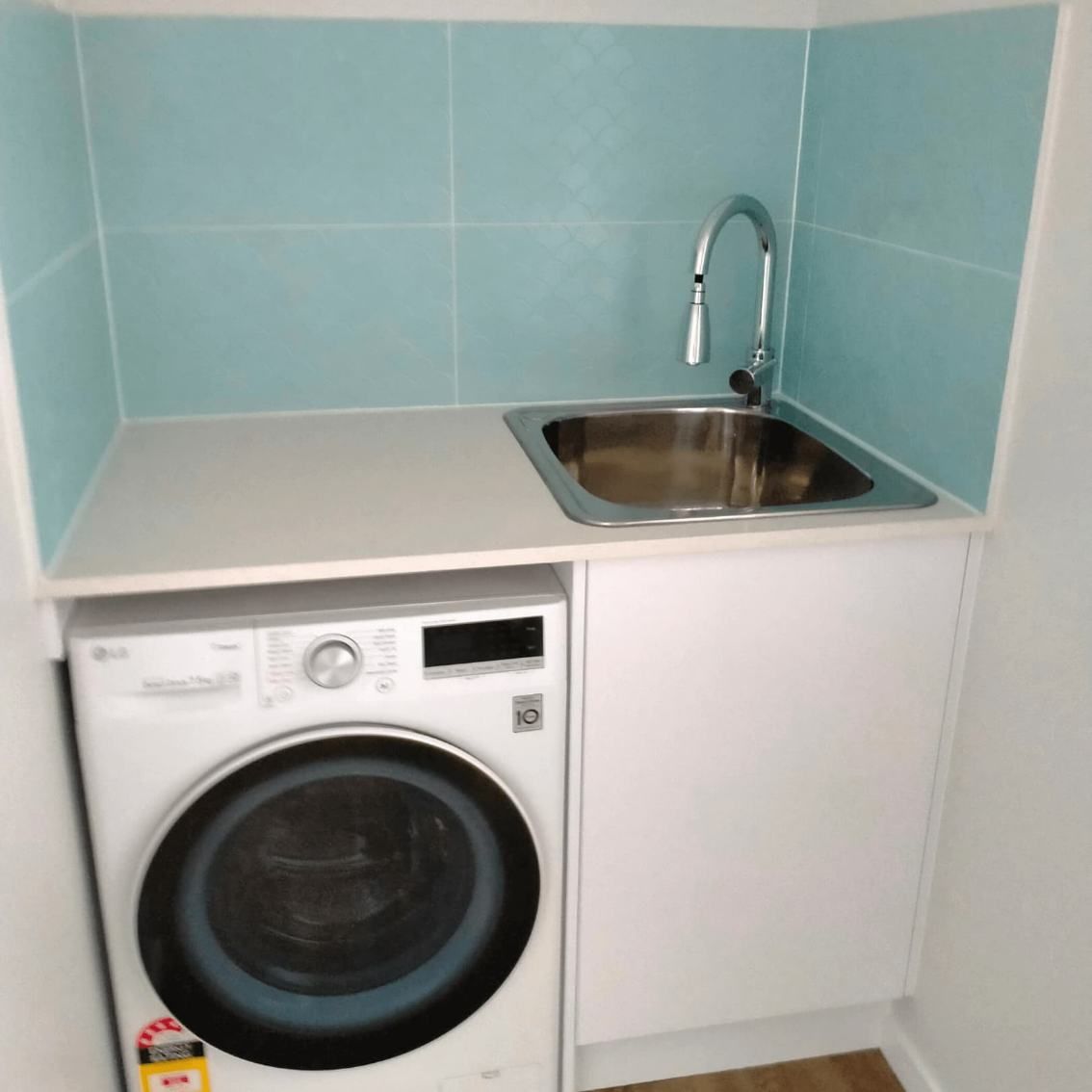 A Well-appointed Laundry Room With A Washing Machine And A Sink — Nyblad Construction in Caloundra West, QLD