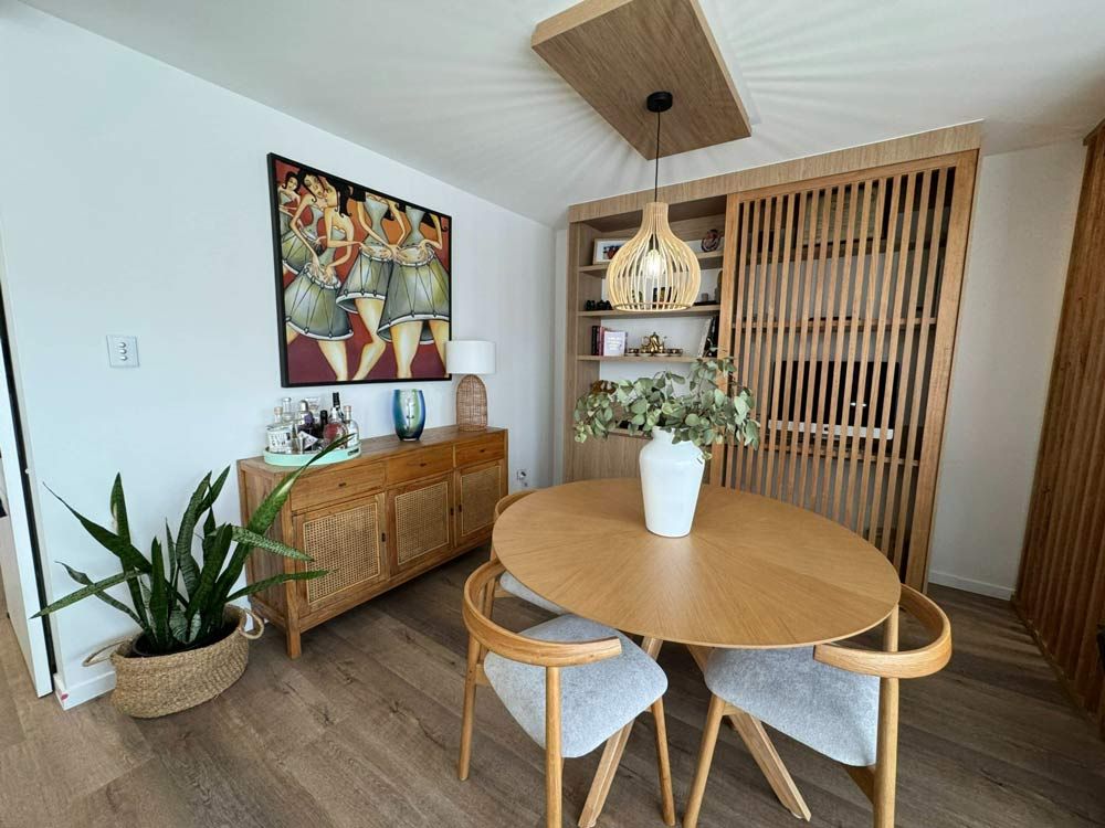 Dining Room With A Round Wooden Table And Chairs — Nyblad Construction in Caloundra West, QLD