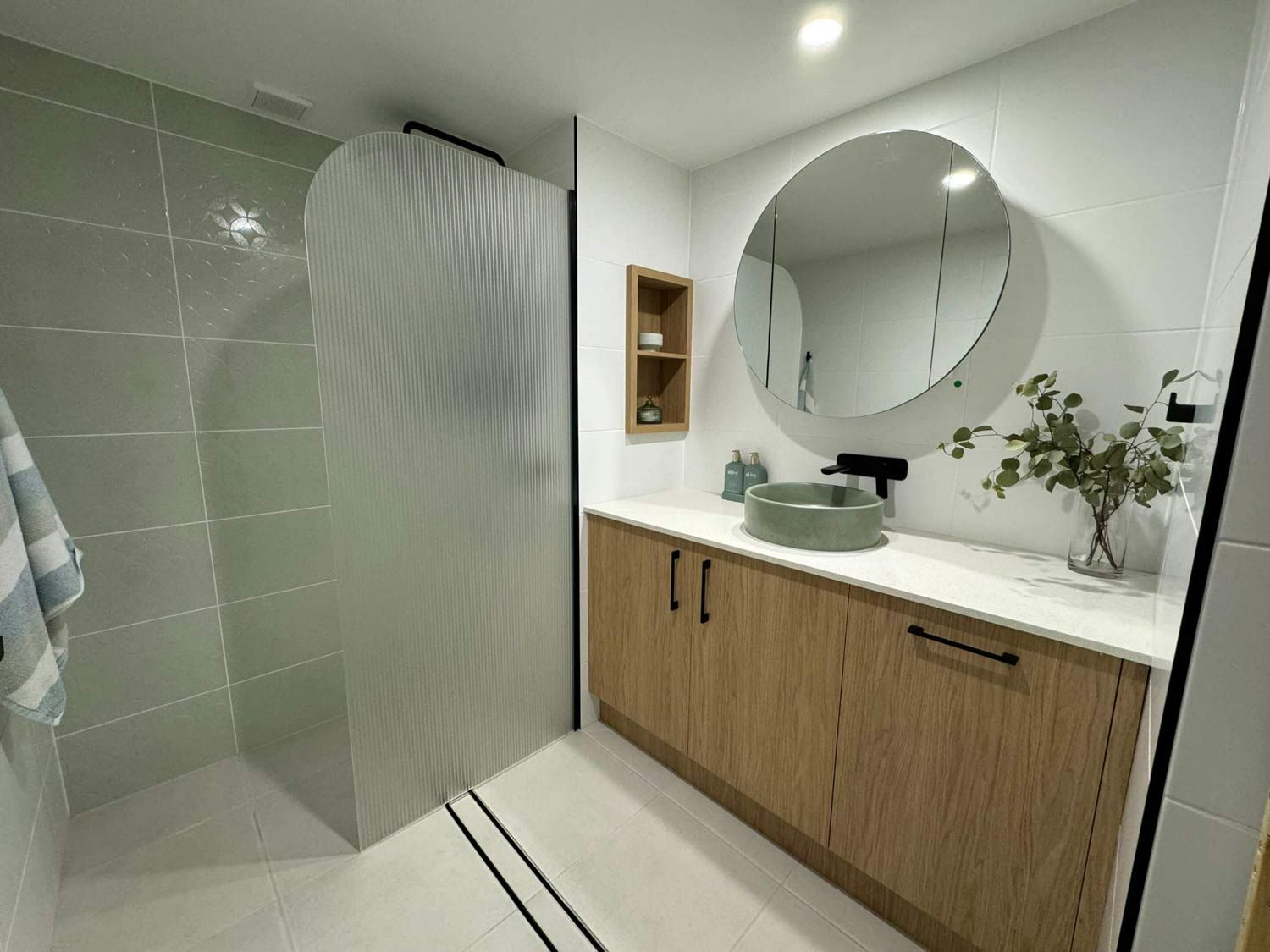 Bathroom With Round Mirror, Cabinet And Spacious Shower Area — Nyblad Construction in Caloundra West, QLD