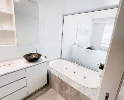 A White Bathroom With A Beautiful Cabinet And A Relaxing Bathtub — Nyblad Construction in Caloundra West, QLD