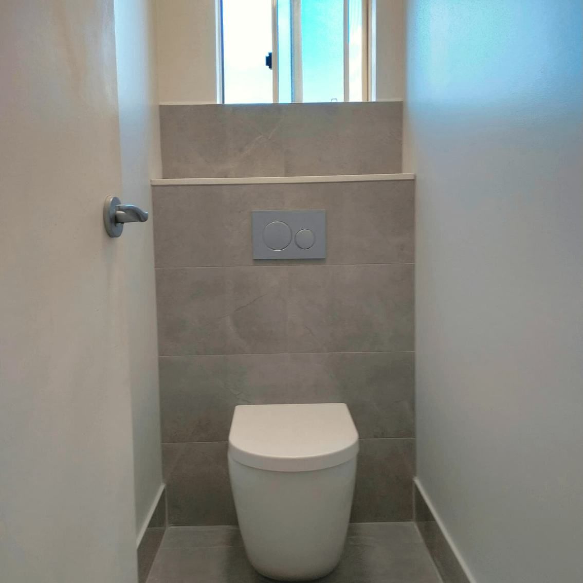 A Compact Bathroom Featuring A Toilet And A Window — Nyblad Construction in Caloundra West, QLD