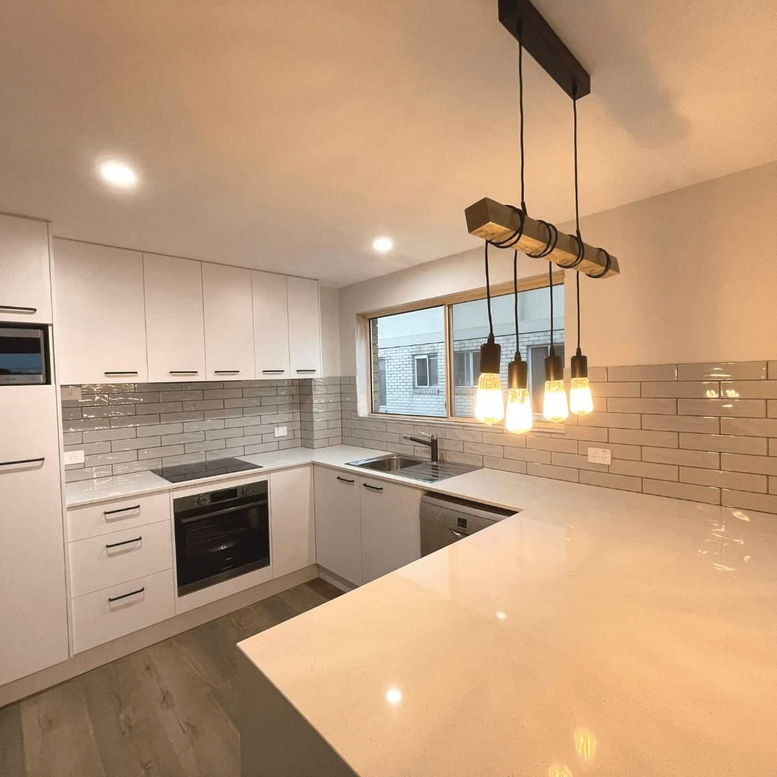 A Modern Spacious Kitchen With A Free-standing Kitchen Island — Nyblad Construction in Caloundra West, QLD