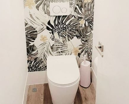 A Toilet In A Bathroom With A Floral Wallpaper On The Wall — Nyblad Construction in Caloundra West, QLD