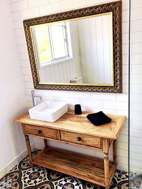 A Bathroom With A Wooden Vanity , Sink And Mirror — Nyblad Construction in Caloundra West, QLD
